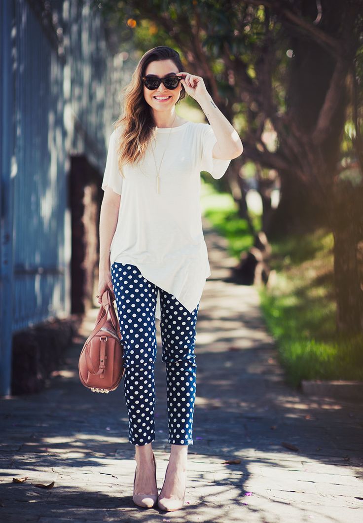 A calça assimétrica e com estampa de poá fica elegante com a blusa branca e o scarpin neutro (Foto: Reprodução)